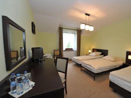 a room with two beds and a table with bottles of water at Zajazd Magda in Kroczyce