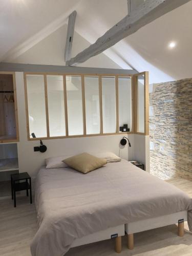 a bedroom with a large bed with white sheets at La Maison du Cocher - Chambre indépendante climatisée en Hypercentre - Lit Queen Size in Angers