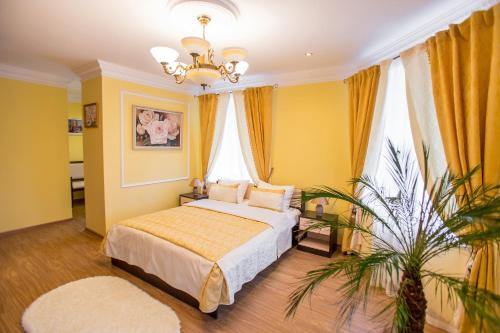 Un dormitorio con una cama con paredes amarillas y una lámpara de araña. en Hotel Benefit, en Perm