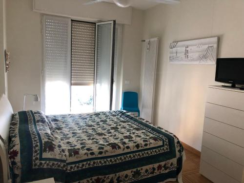 een slaapkamer met een bed, een raam en een televisie bij Giusy near the sea in Sanremo