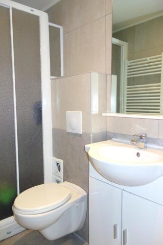 une salle de bain avec des toilettes blanches et un lavabo dans l'établissement Apartment Palais de France, à Nice
