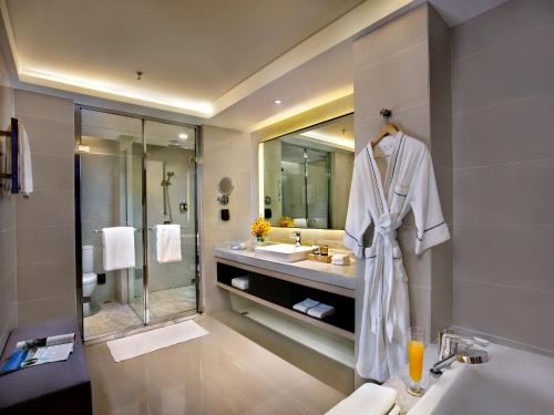 a bathroom with a robe hanging on a wall at Mercure Dalian City Center in Dalian