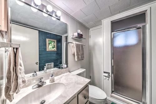 La salle de bains blanche est pourvue d'un lavabo et d'une douche. dans l'établissement Mid-Century Modern Ruidoso Cabin with Hot Tub!, à Ruidoso
