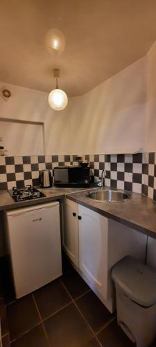 a kitchen with a sink and a counter top at Chambres d'hôtes au Pays des Etangs in Bourgaltroff