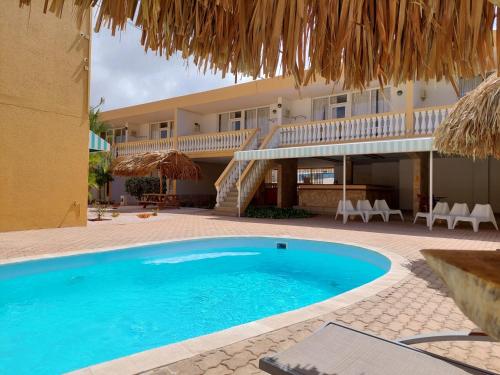 a swimming pool in front of a villa at Montana Eco Resort Aruba in Oranjestad