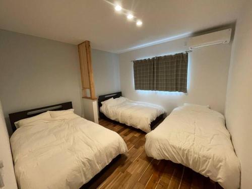 a bedroom with two beds and a window at Doublerainbow Resort Katsuura in Katsuura