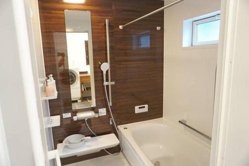 uma casa de banho com um chuveiro, uma banheira e um lavatório. em Doublerainbow Resort Katsuura em Katsuura