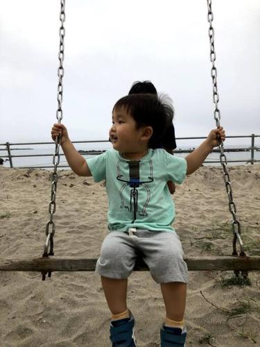 a little girl sitting on a swing at Doublerainbow Resort Katsuura in Katsuura