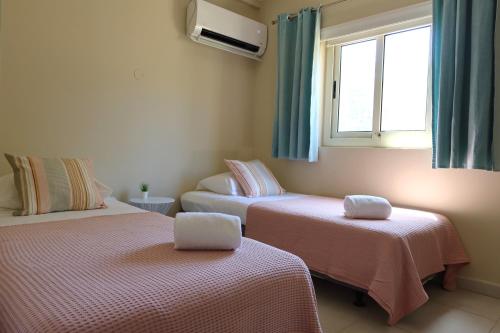 オラニエスタッドにあるMontana Eco Resort Arubaのベッド2台と窓が備わる客室です。