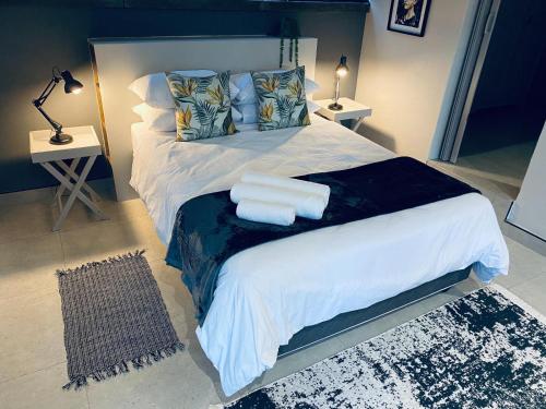- une chambre avec un grand lit et 2 serviettes dans l'établissement 46 on Allcock Guest Apartment & Luxury Room, à Pretoria