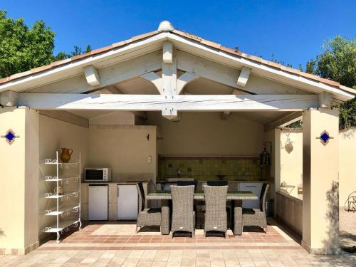 - un pavillon avec une table et des chaises sur la terrasse dans l'établissement Villa Avila, à La Farlède