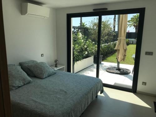 Schlafzimmer mit einem Bett und einer Glasschiebetür in der Unterkunft BLUEBAY2 Bandol Appartement T2 Face à la mer in Bandol