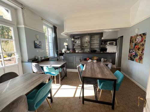 - une cuisine et une salle à manger avec des tables et des chaises en bois dans l'établissement Chambres d'hôtes & Spa Les Perce Neige, à Vernou-sur-Brenne