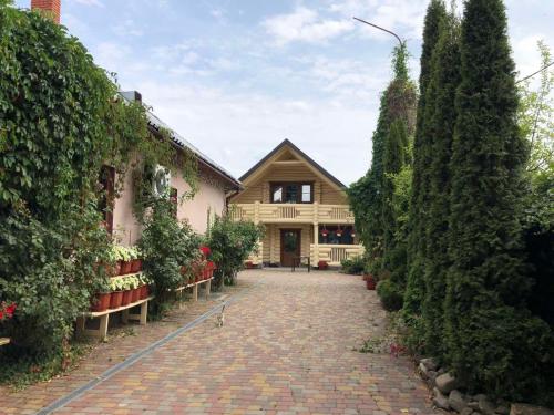 a house with a brick driveway in front of a building at Smerekova Hata in Mizhhirya