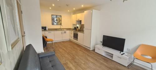 a kitchen with a couch and a tv in a room at Empress at College - Spacious 2 bedroom apartment in Southampton