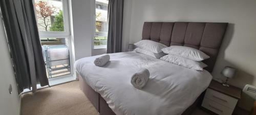 ein Schlafzimmer mit einem großen Bett mit weißer Bettwäsche und Kissen in der Unterkunft Empress at College - Spacious 2 bedroom apartment in Southampton