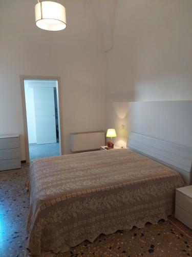 1 dormitorio con cama, lámpara y espejo en Casa Vacanze Lu Trappitu, en Magliano