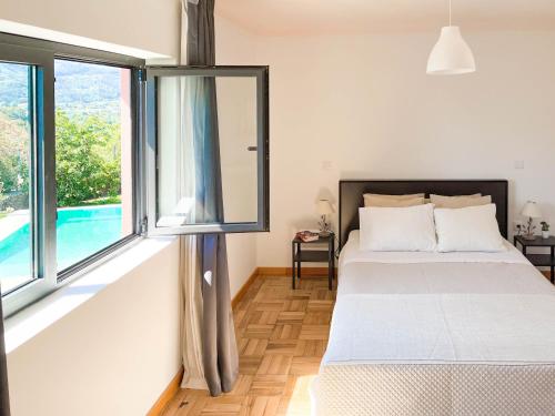 ein Schlafzimmer mit einem Bett und einem großen Fenster in der Unterkunft Casa Lima in Coucieiro