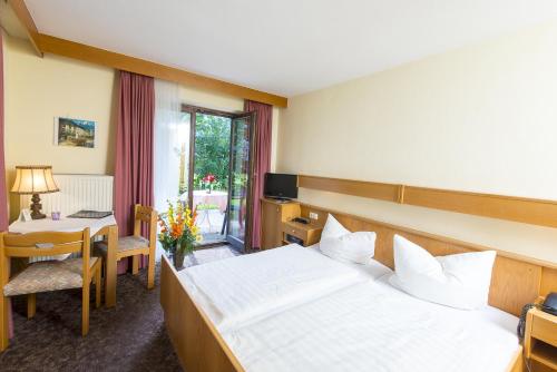 シェーナウ・アム・ケーニッヒスゼーにあるホテル コペレックのベッドとテーブルが備わるホテルルームです。