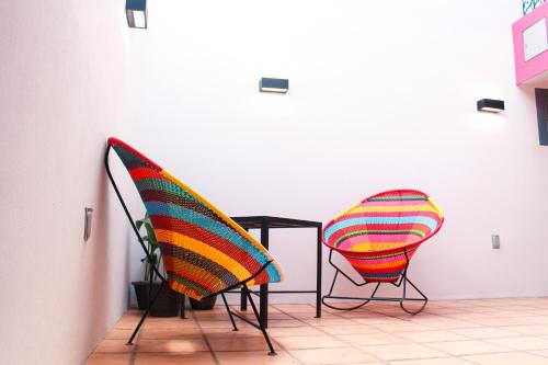 two chairs and a table in a room at Casa Rosa Mexicano in Oaxaca City