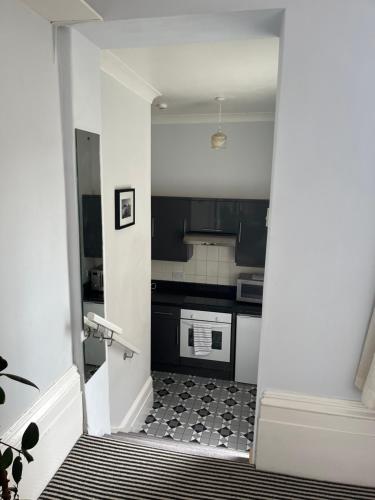 a kitchen with black and white appliances and a stairway at Studio flat Brighton Hove border in Brighton & Hove