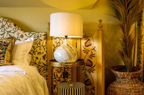a lamp sitting on a table next to a bed at HIGHFIELD in Great Driffield