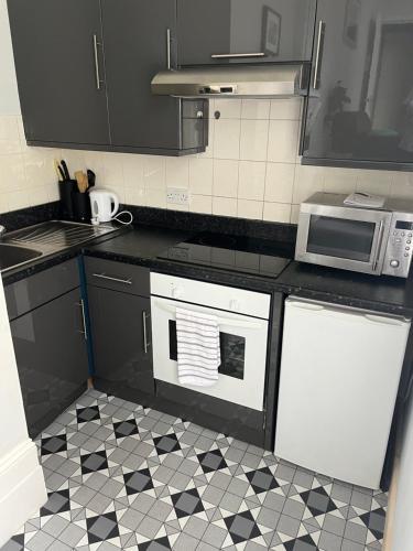 a kitchen with a black and white tile floor at Studio flat Brighton Hove border in Brighton & Hove