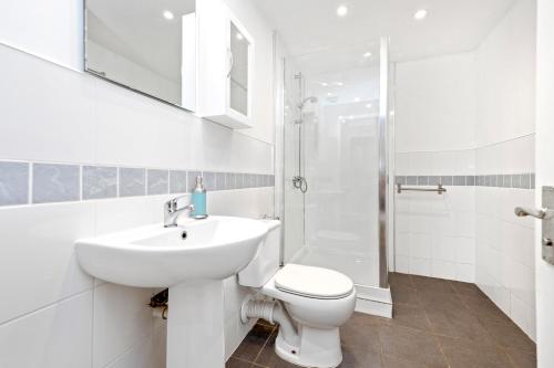 uma casa de banho com um WC, um lavatório e um chuveiro em ALTIDO Cosy 3bed Family flat near Leith em Edinburgo