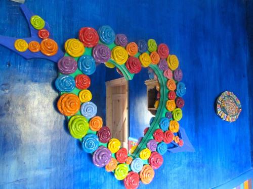 a mirror in the shape of a heart on a blue wall at Western House in Llangennith