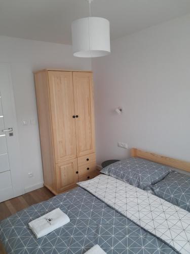 a bedroom with two beds and a wooden cabinet at Domek na Kępie in Sromowce Wyżne