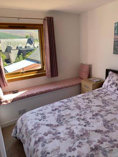 a bedroom with a bed and a window with a view at Pannanich View Cottage, Ballater in Ballater