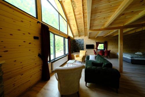 a living room with wood paneled walls and windows at AYDER Levut Dağ Evi in Ayder Yaylasi