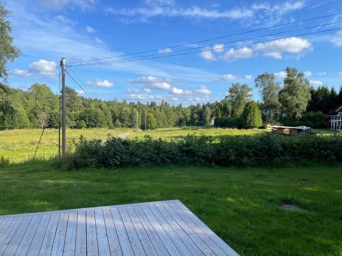 a view of a field with a wooden deck at Hultakulla in Lindome