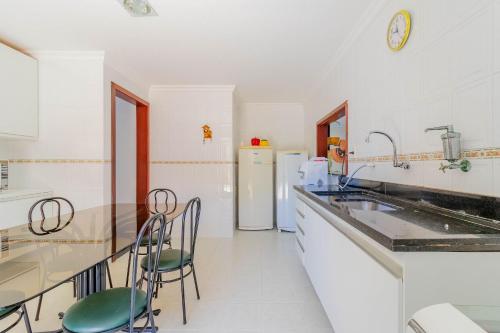 a kitchen with a sink and a counter with chairs at GB09 Ótima Casa 6 Quartos a 50m da Praia in Guarajuba