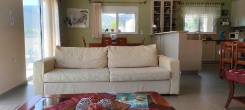 sala de estar con sofá blanco y mesa en KimonVilla, en Porto Rafti
