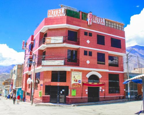a red brick building with a hotel sign on it at Hotel Cordillera Blanca in Caraz