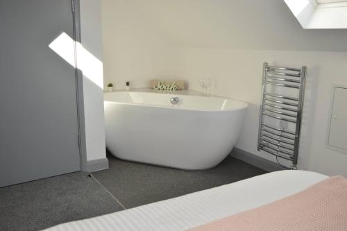 een witte badkamer met een groot bad in een kamer bij Pier12 in Eastbourne