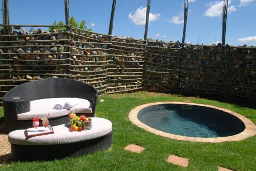 un patio trasero con una bañera de hidromasaje en el césped en Forum Homini Boutique Hotel, en Krugersdorp