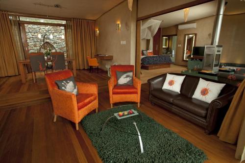 a living room with a couch and two chairs at Forum Homini Boutique Hotel in Krugersdorp