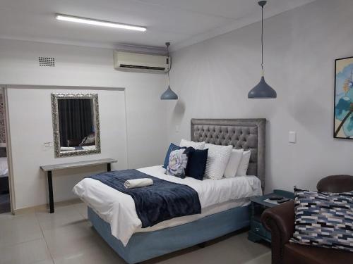 克莱克斯多普The Guesthouse Klerksdorp的一间卧室配有一张大床和一张沙发