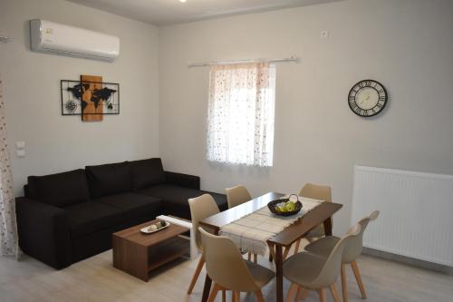 uma sala de estar com uma mesa e um sofá em VIRGIN ROCKs APARTMENT 2 em Kalabaka