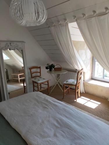 une chambre avec un lit, une table et des chaises dans l'établissement Le Clos Pontillon - Maison d'hôtes, à Rémalard