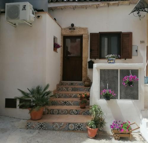 a front door of a house with potted plants at Blue Cottage monolocale centro Sciacca in Sciacca