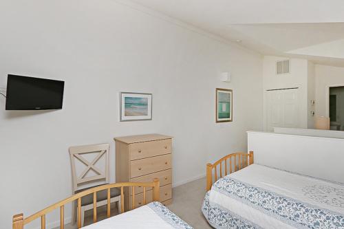 a bedroom with two beds and a tv on the wall at Sea Colony - 55021 Pine Lake in Bethany Beach