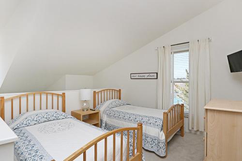 a bedroom with two beds and a tv and a window at Sea Colony - 55021 Pine Lake in Bethany Beach