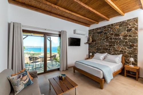 a bedroom with a bed and a stone wall at Enastron Apartments in Sitia