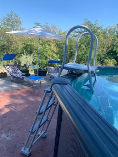 una escalera junto a una piscina con sombrilla en Ca' degli Ovi, en Valenza