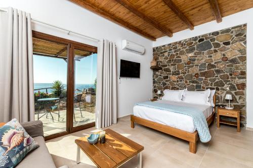 a bedroom with a bed and a stone wall at Enastron Apartments in Sitia