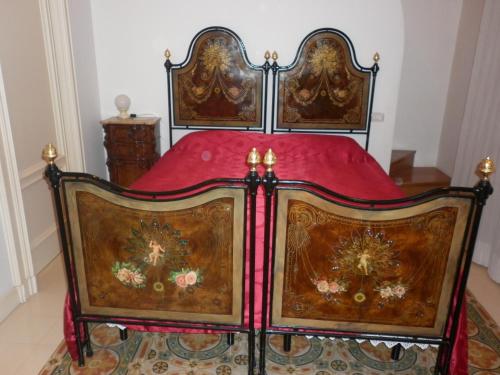an ornate bed with red sheets and a red blanket at Lilla B&B in Molfetta