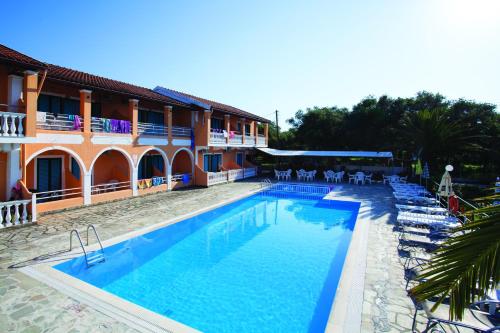 a swimming pool in front of a hotel at Valentinos Apartments in Roda